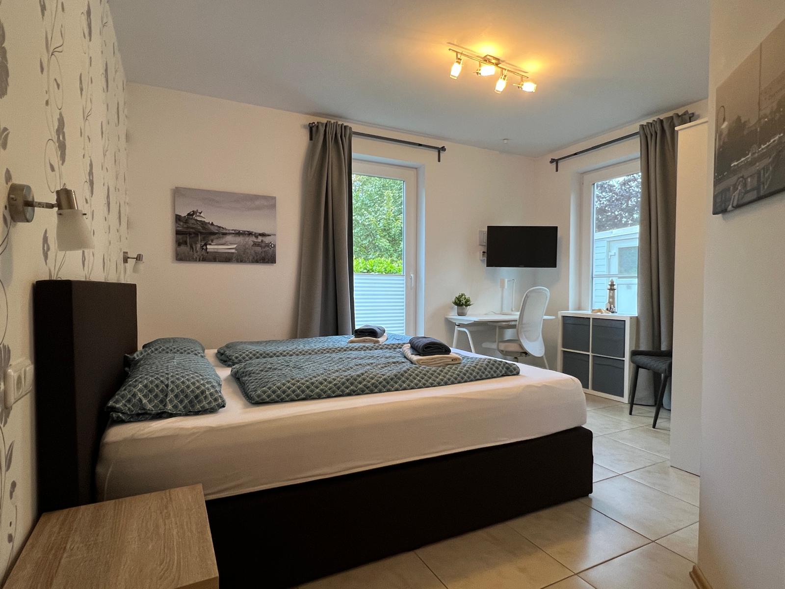 Gemütliches Schlafzimmer mit Doppelbett und Flatscreen-TV